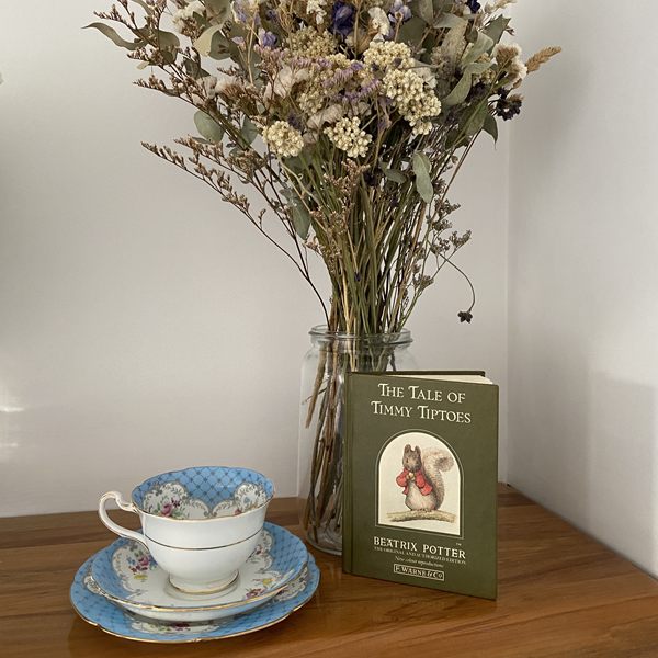 Beatrix potter book with blue vintage china teacup, styled for a boy baby shower,